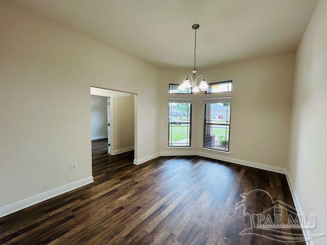 5643 Flume Dr, Pace, FL 32571 - unfurnished room featuring a chandelier, dark wood-style floors, and baseboards