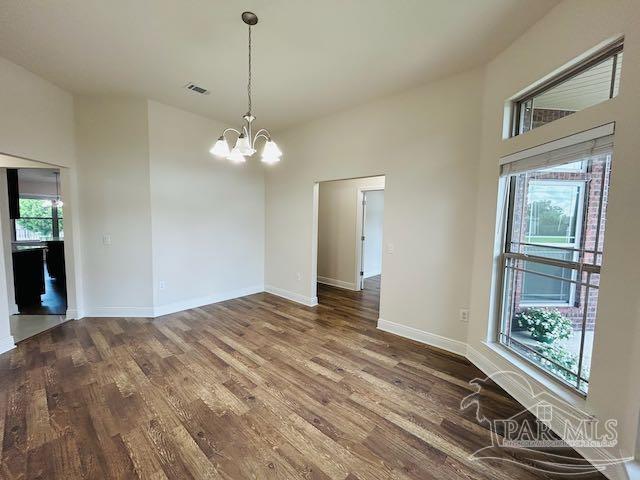5643 Flume Dr, Pace, FL 32571 - unfurnished room with a chandelier, wood finished floors, and baseboards