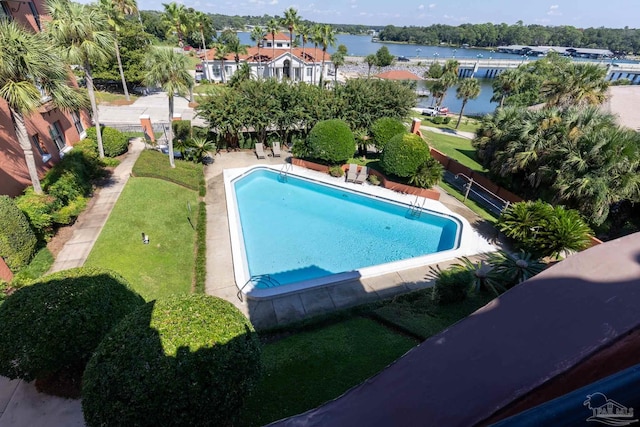 view of pool featuring a yard and a water view