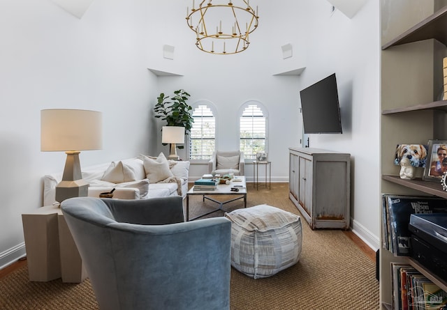 carpeted living room with a high ceiling and an inviting chandelier