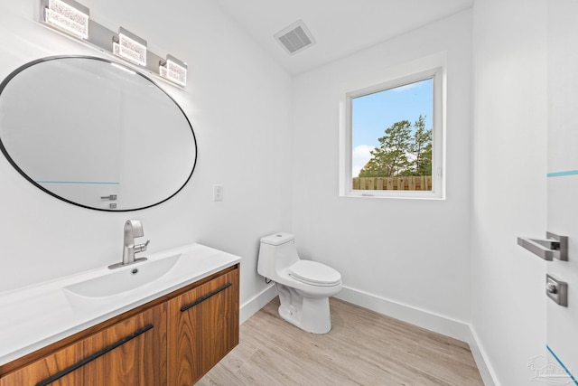 bathroom featuring wood-type flooring, vanity, and toilet