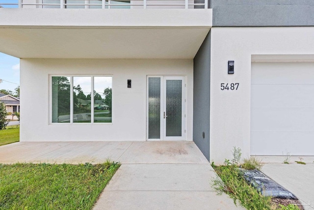 doorway to property with a balcony and french doors