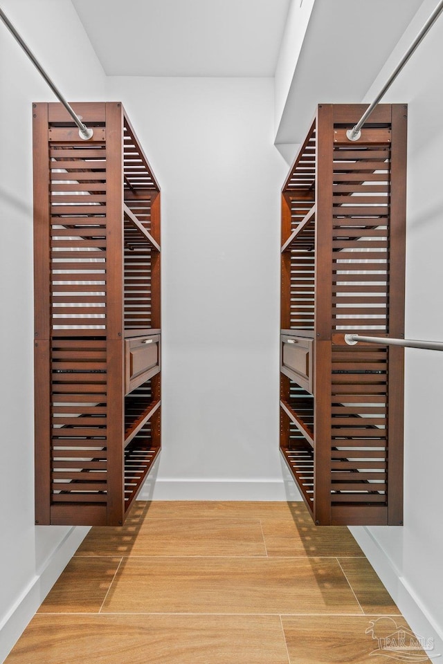 walk in closet with wood-type flooring