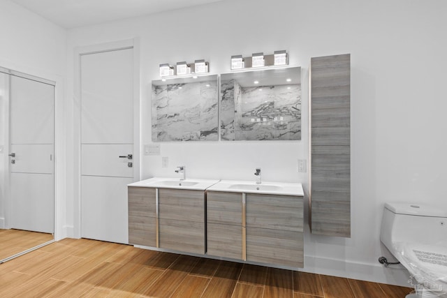 bathroom with hardwood / wood-style floors, vanity, and toilet