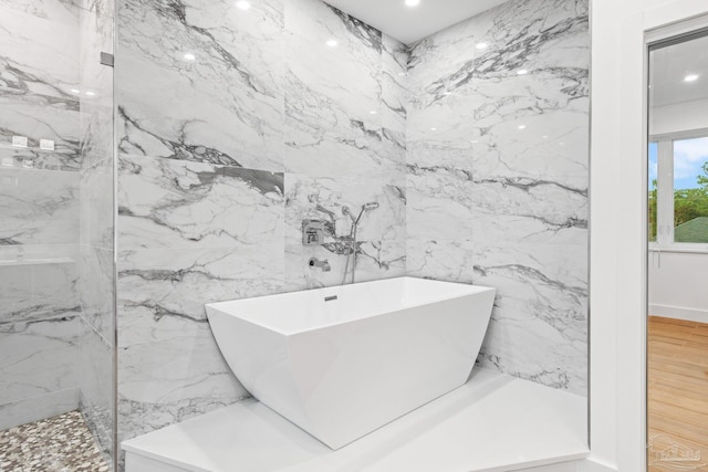 bathroom featuring separate shower and tub, tile walls, and hardwood / wood-style flooring