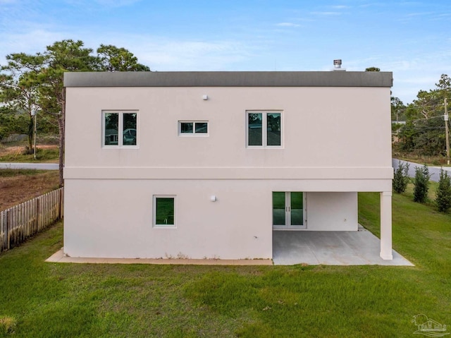 back of house with a yard and a patio