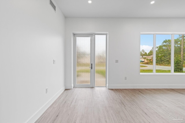 empty room with light hardwood / wood-style flooring and french doors