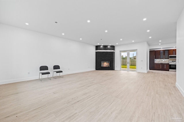 unfurnished living room featuring a fireplace and light hardwood / wood-style flooring