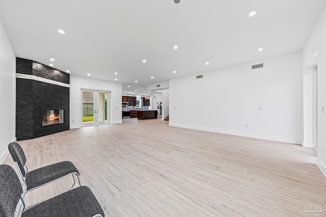 unfurnished living room featuring a fireplace and light hardwood / wood-style flooring