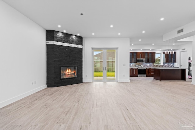 unfurnished living room featuring a fireplace and light hardwood / wood-style flooring