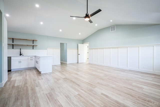 unfurnished living room featuring ceiling fan, sink, light hardwood / wood-style floors, and lofted ceiling