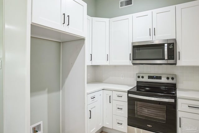 kitchen with decorative backsplash, appliances with stainless steel finishes, and white cabinetry