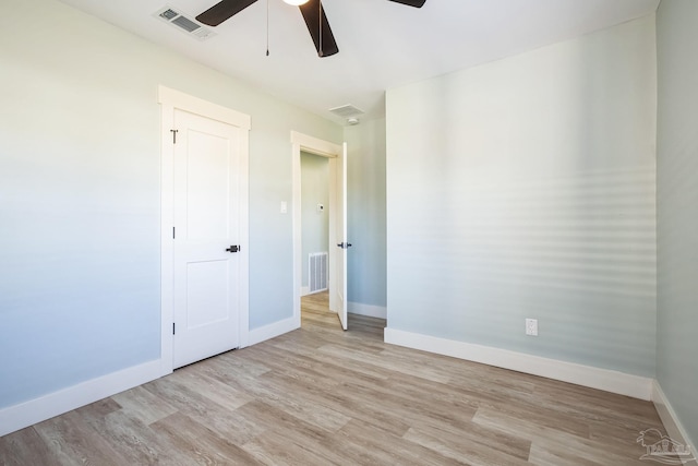 empty room with ceiling fan and light hardwood / wood-style flooring