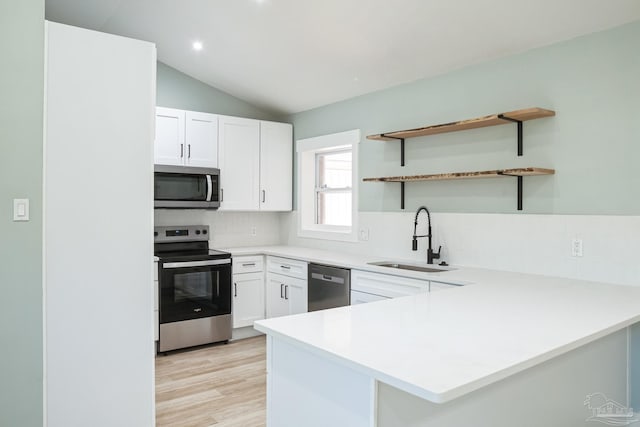 kitchen featuring sink, kitchen peninsula, decorative backsplash, white cabinetry, and stainless steel appliances