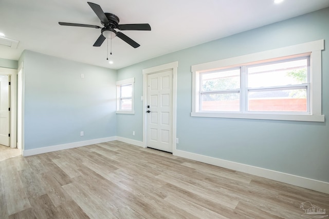 spare room with ceiling fan, plenty of natural light, and light wood-type flooring