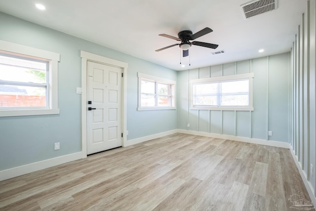 spare room featuring ceiling fan, a healthy amount of sunlight, and light hardwood / wood-style floors