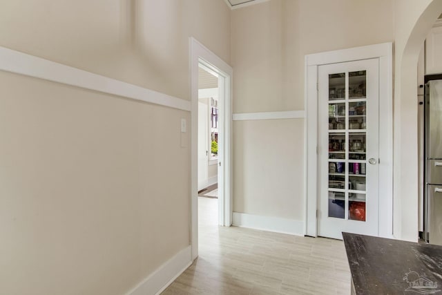 hall featuring baseboards and arched walkways