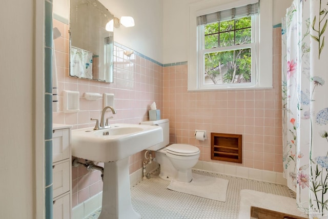 bathroom with toilet, tile walls, tile patterned flooring, and a shower with shower curtain