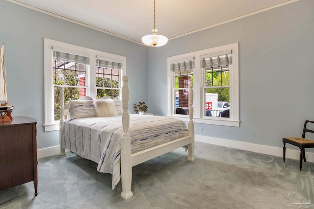 carpeted bedroom featuring baseboards, multiple windows, and crown molding