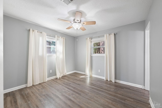 unfurnished room with a textured ceiling, wood finished floors, a ceiling fan, and baseboards