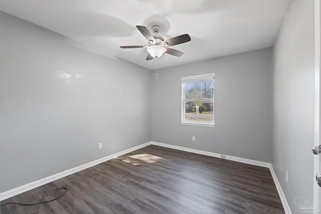 spare room featuring a textured ceiling, dark wood-style flooring, a ceiling fan, and baseboards