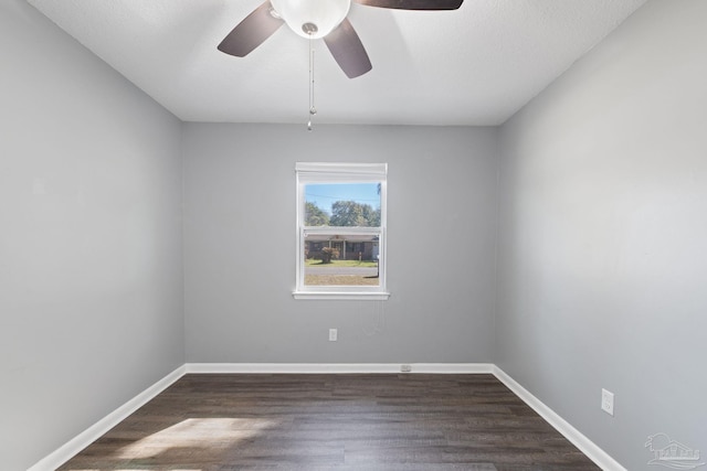 unfurnished room featuring dark wood-type flooring, baseboards, and a ceiling fan