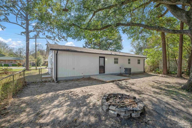 back of house with a patio, an outdoor fire pit, a fenced backyard, and central air condition unit