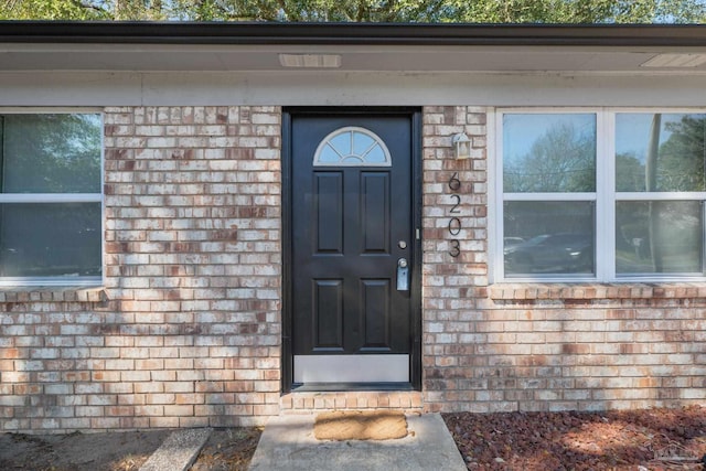 view of exterior entry with brick siding