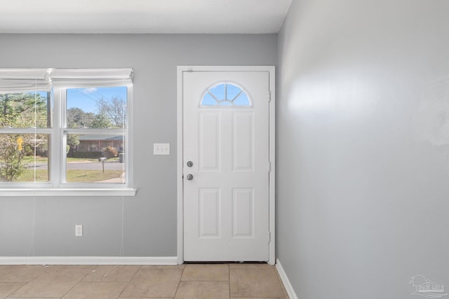 foyer entrance featuring baseboards and light tile patterned floors