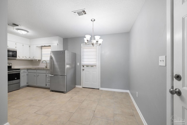 kitchen featuring baseboards, visible vents, stainless steel appliances, and a sink