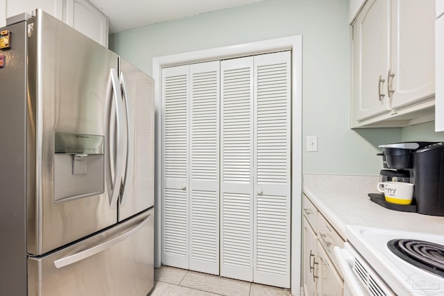 8425 Gulf Blvd Unit 213, Navarre Beach, FL 32566 - kitchen featuring stainless steel refrigerator with ice dispenser, light countertops, white cabinetry, and light tile patterned floors