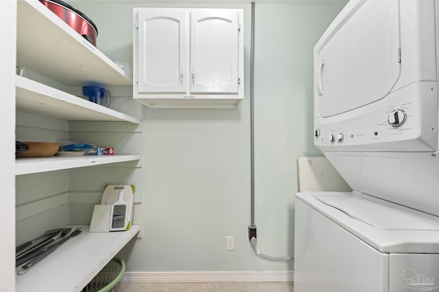 8425 Gulf Blvd Unit 213, Navarre Beach, FL 32566 - washroom featuring stacked washer / dryer, baseboards, and cabinet space
