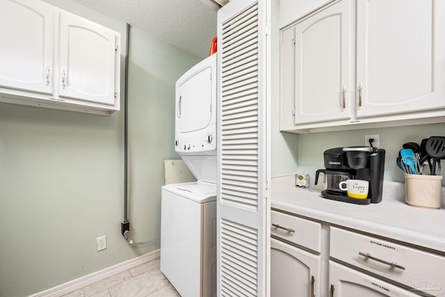 8425 Gulf Blvd Unit 213, Navarre Beach, FL 32566 - laundry room with stacked washer / dryer, baseboards, light tile patterned floors, and a textured ceiling