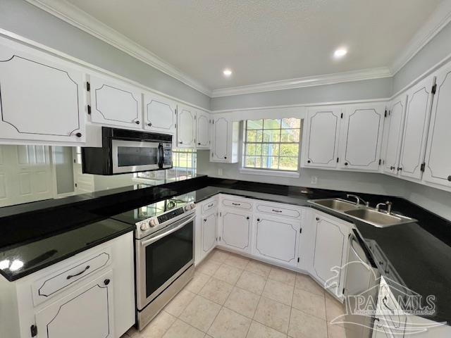 kitchen featuring sink, light tile patterned floors, ornamental molding, white cabinetry, and stainless steel appliances