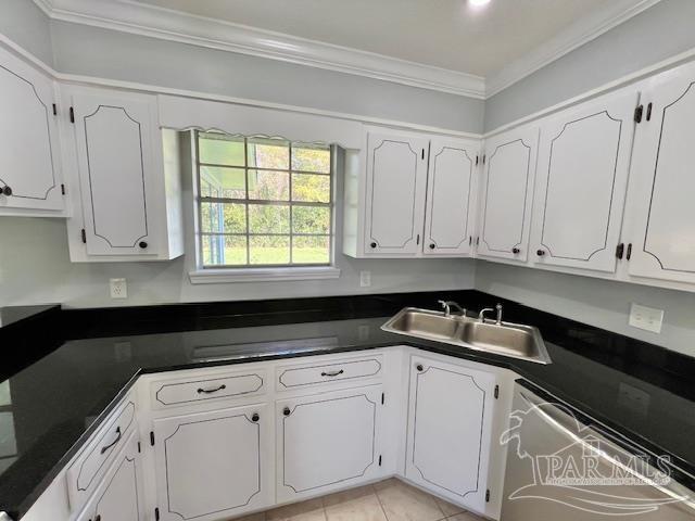 kitchen with white cabinetry, dishwasher, sink, crown molding, and light tile patterned floors