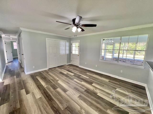 unfurnished bedroom with ceiling fan, dark hardwood / wood-style floors, ornamental molding, and a closet