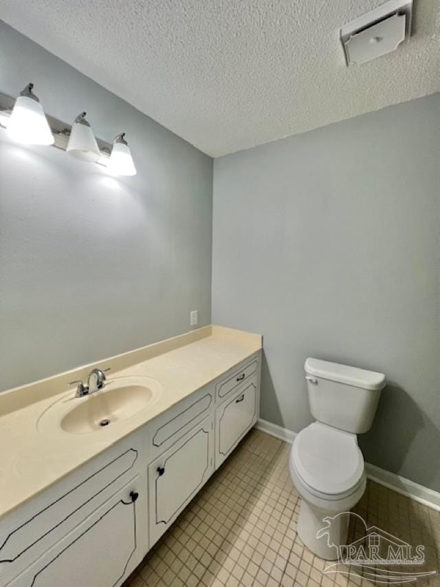 bathroom with vanity, a textured ceiling, and toilet