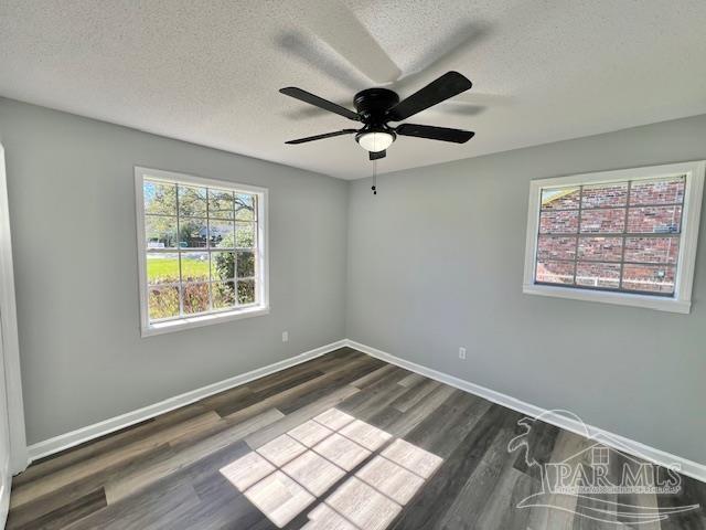 unfurnished room featuring dark hardwood / wood-style floors, ceiling fan, and a textured ceiling