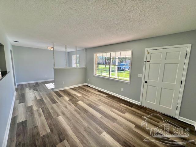 empty room with hardwood / wood-style floors and a textured ceiling