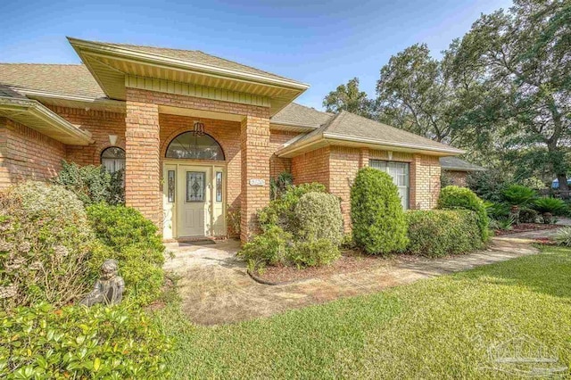 doorway to property featuring a lawn