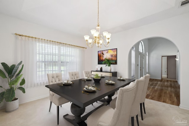 dining area with a notable chandelier and light colored carpet