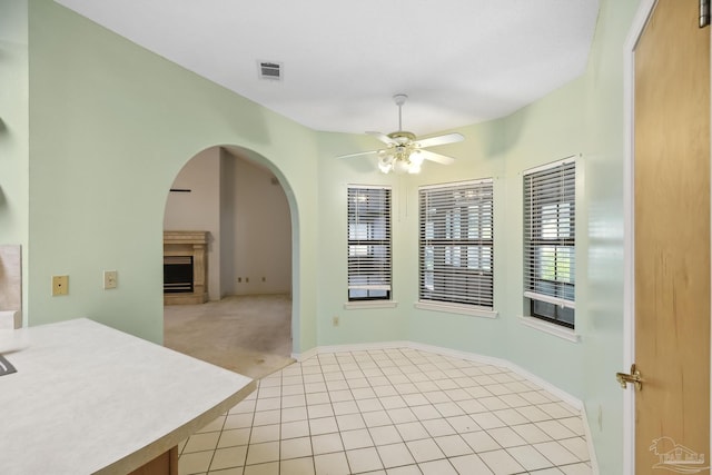 unfurnished dining area with ceiling fan and light carpet