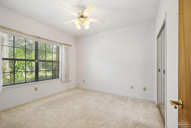 empty room featuring light carpet and ceiling fan