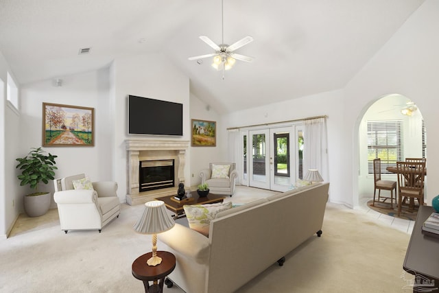 carpeted living room featuring a fireplace, french doors, high vaulted ceiling, and ceiling fan