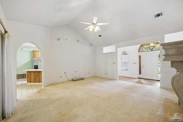 unfurnished living room featuring light carpet, ceiling fan, and high vaulted ceiling