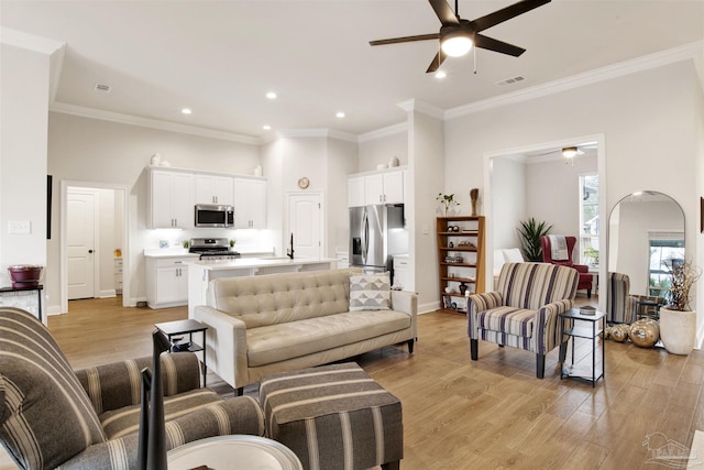 living room featuring light hardwood / wood-style flooring, ornamental molding, and ceiling fan