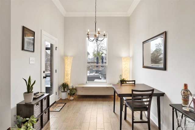 dining room featuring an inviting chandelier, ornamental molding, and light wood-type flooring