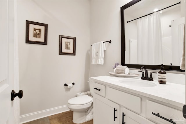 bathroom featuring vanity, hardwood / wood-style floors, and toilet