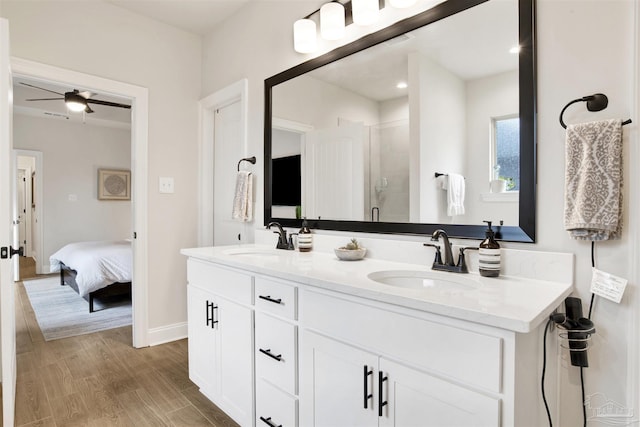 bathroom with vanity, hardwood / wood-style floors, a shower with door, and ceiling fan