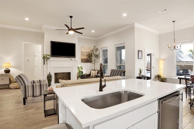 kitchen featuring sink, white cabinetry, decorative light fixtures, an island with sink, and light stone countertops